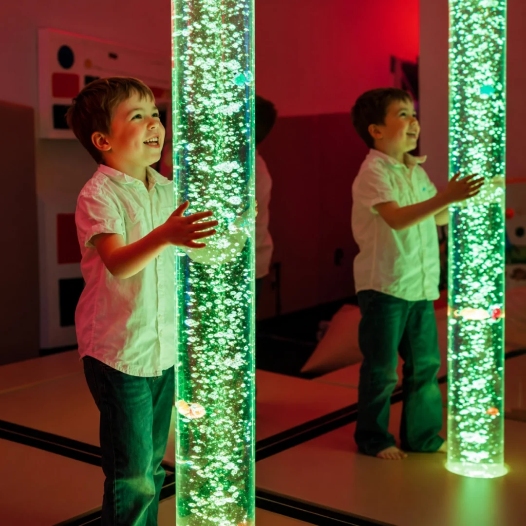 Child enjoying colorful bubble tube lights.