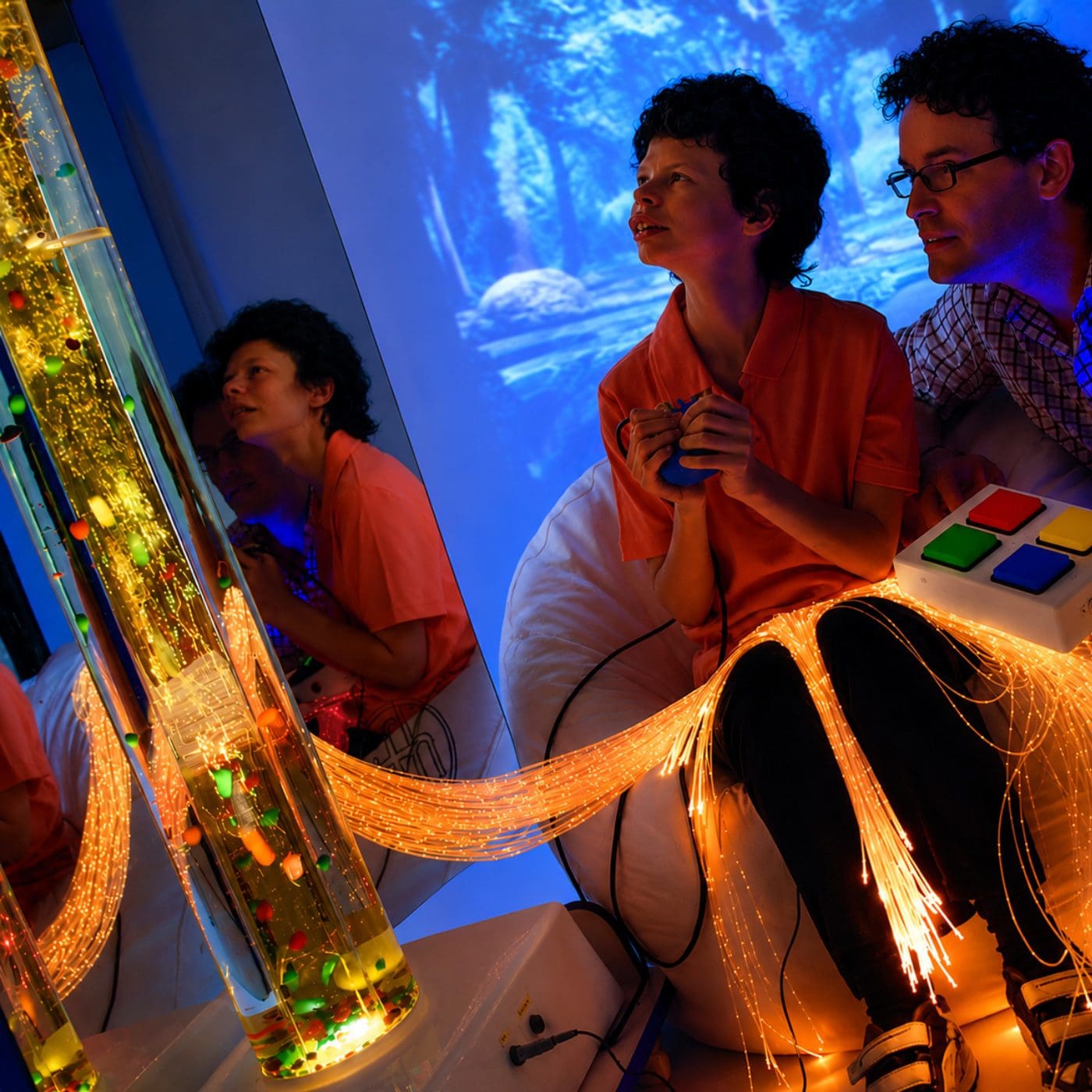 Child engaging with sensory bubble tube display.