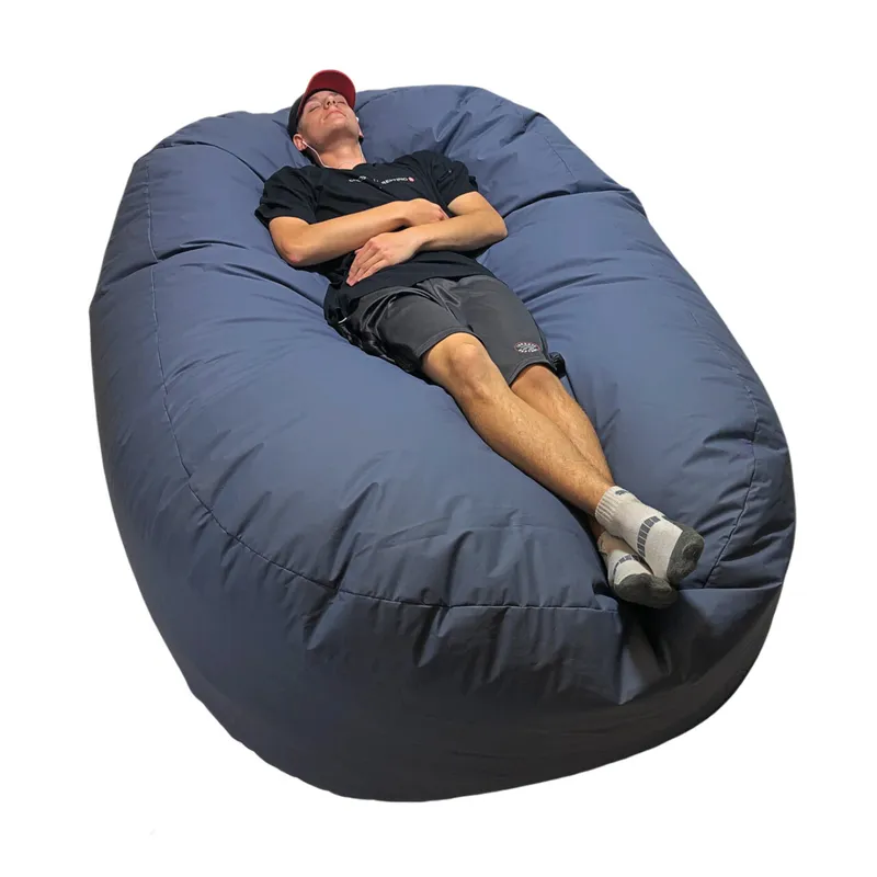Man relaxing on oversized gray bean bag